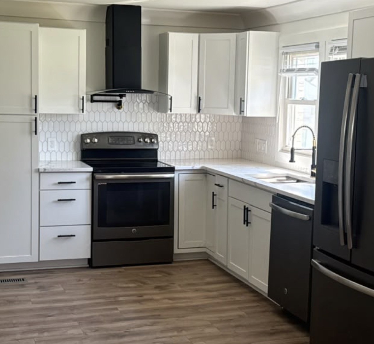 SAM Renovations kitchen with white cabinets and a patterned backsplash